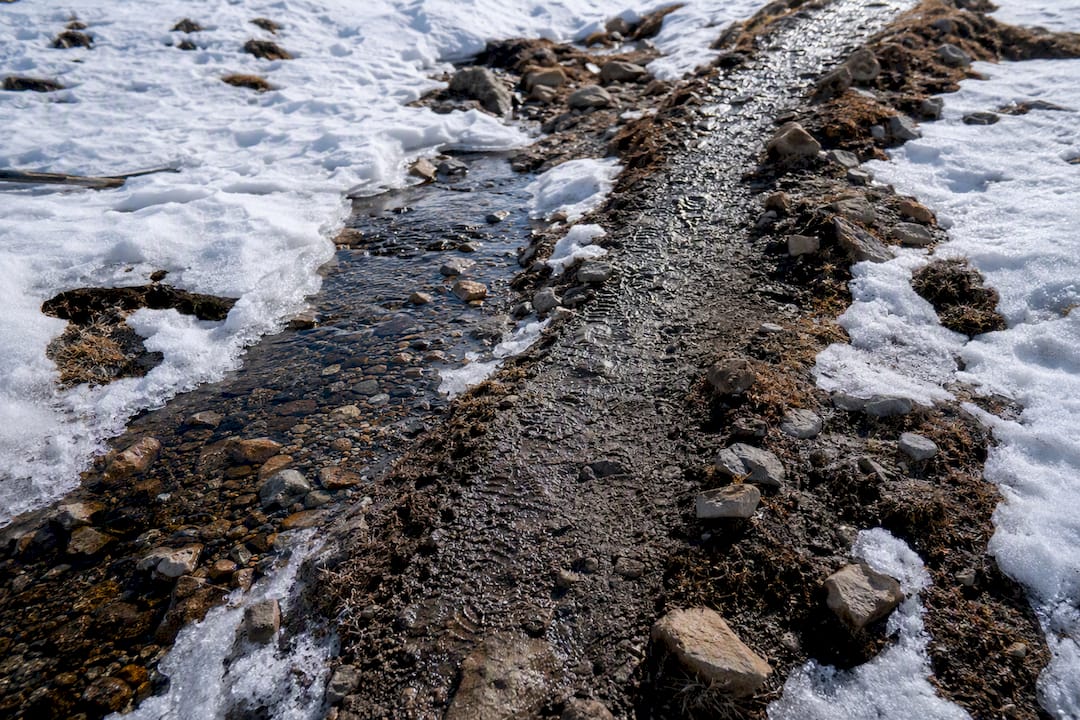Frozen trail terrain during snowmelt season