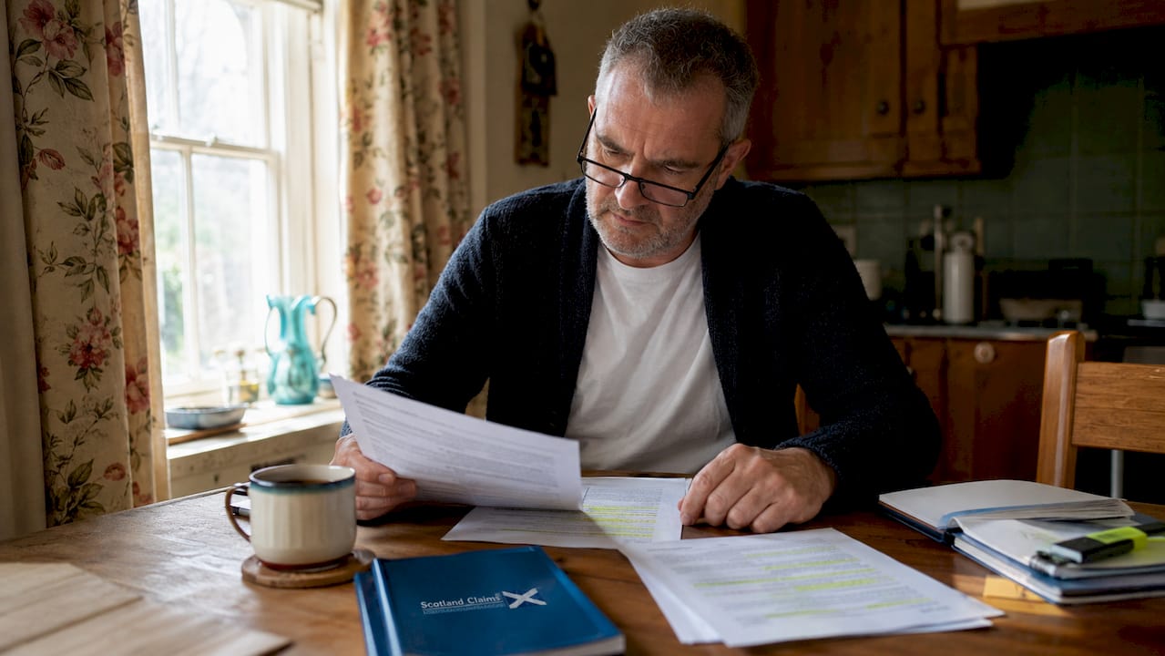 Man reviewing employer liability papers at office desk