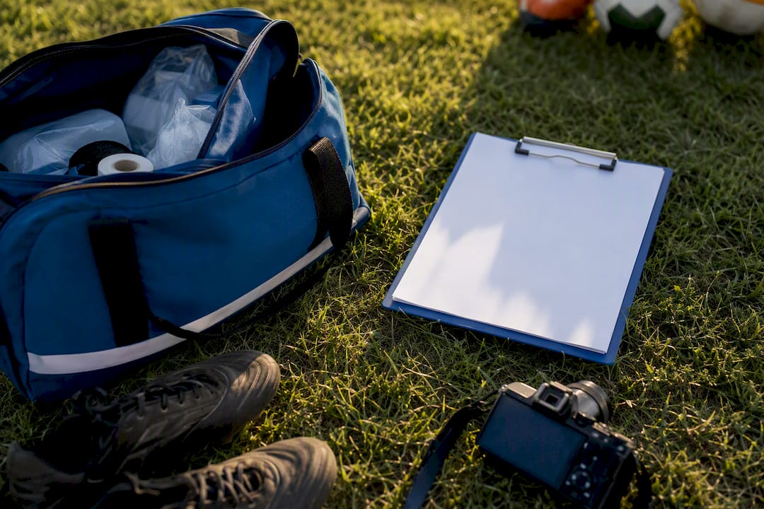Sports injury kit and clipboard on grass