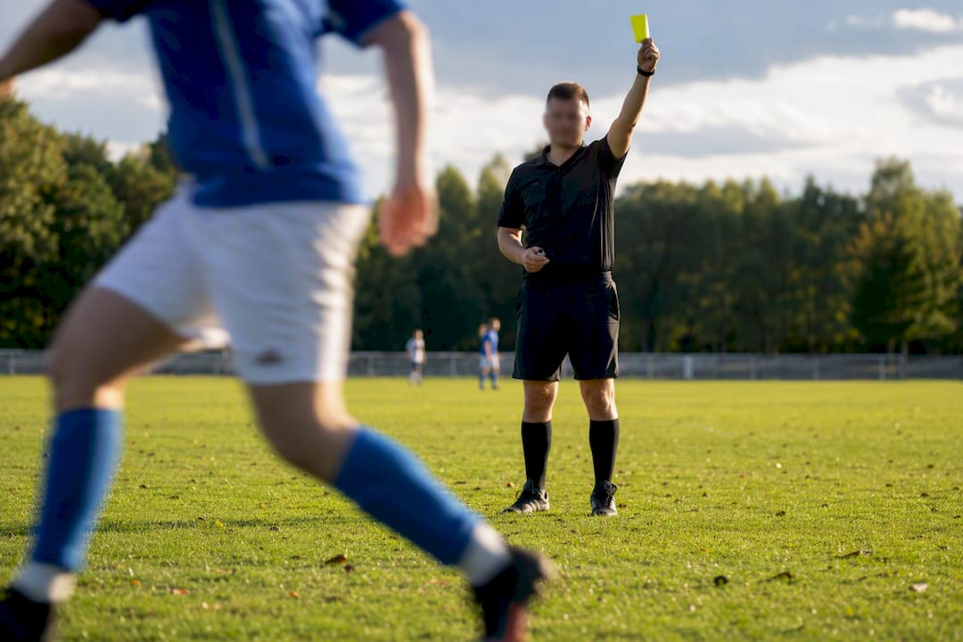 Referee issuing card during amateur football match