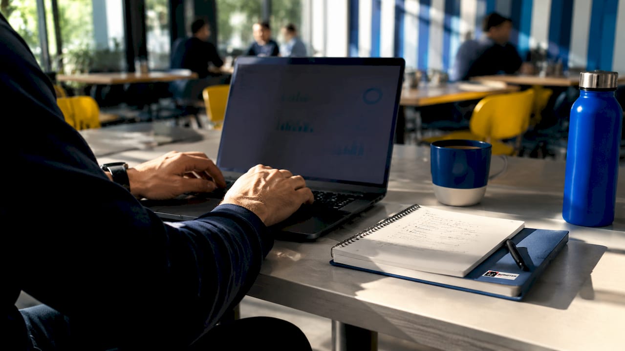 Hands typing keyboard with SEO notes overhead view