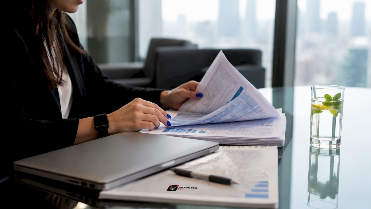 Close-up of business analyst handling customer data sheets