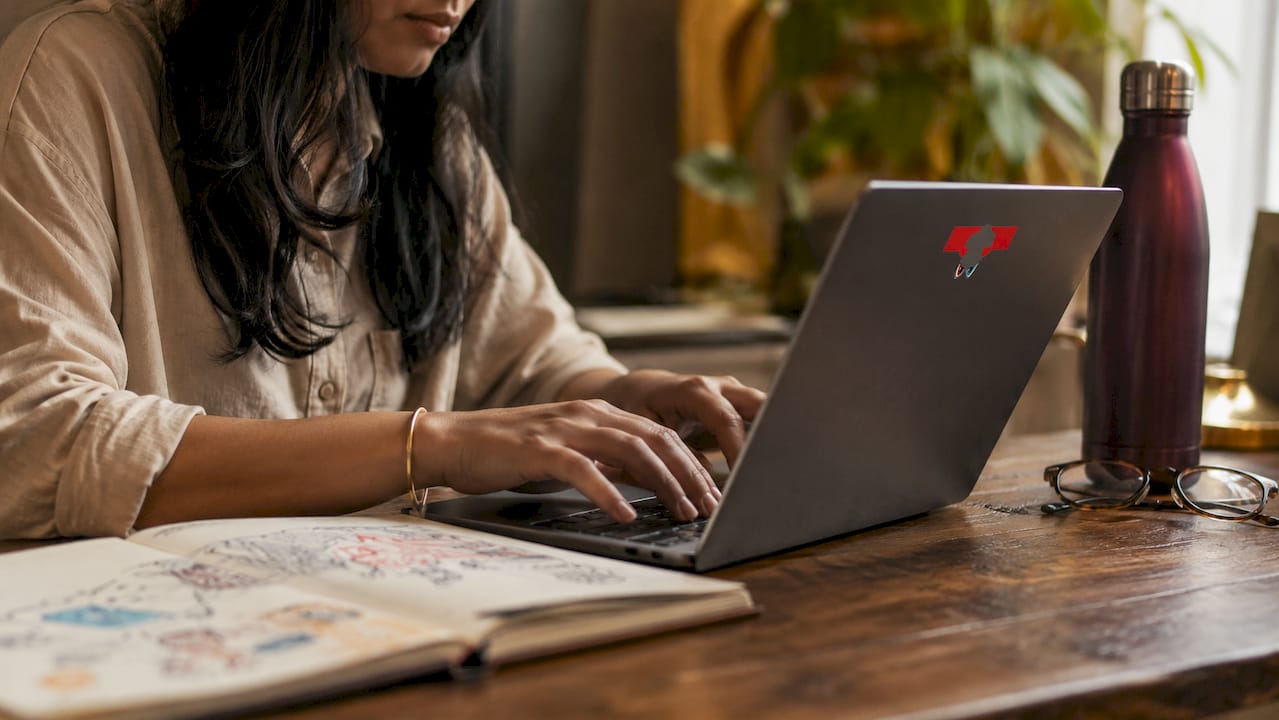 Hands clicking mouse at glass desk with notebook