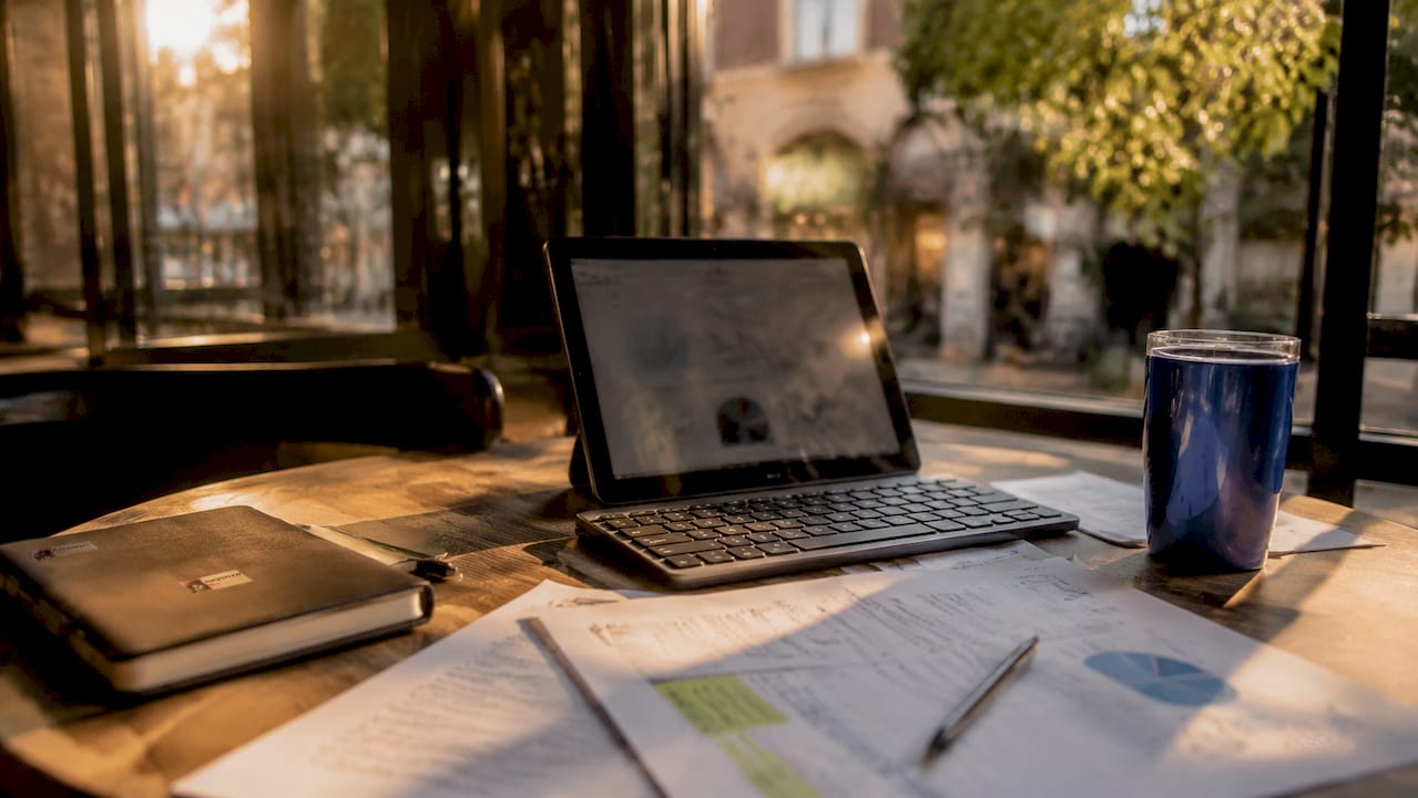 Overhead of desk with SEO content reports and tablet