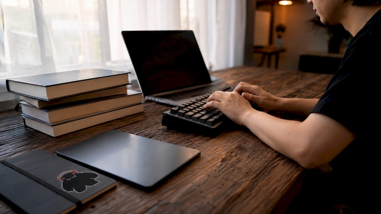 Hands typing keyword research process on keyboard