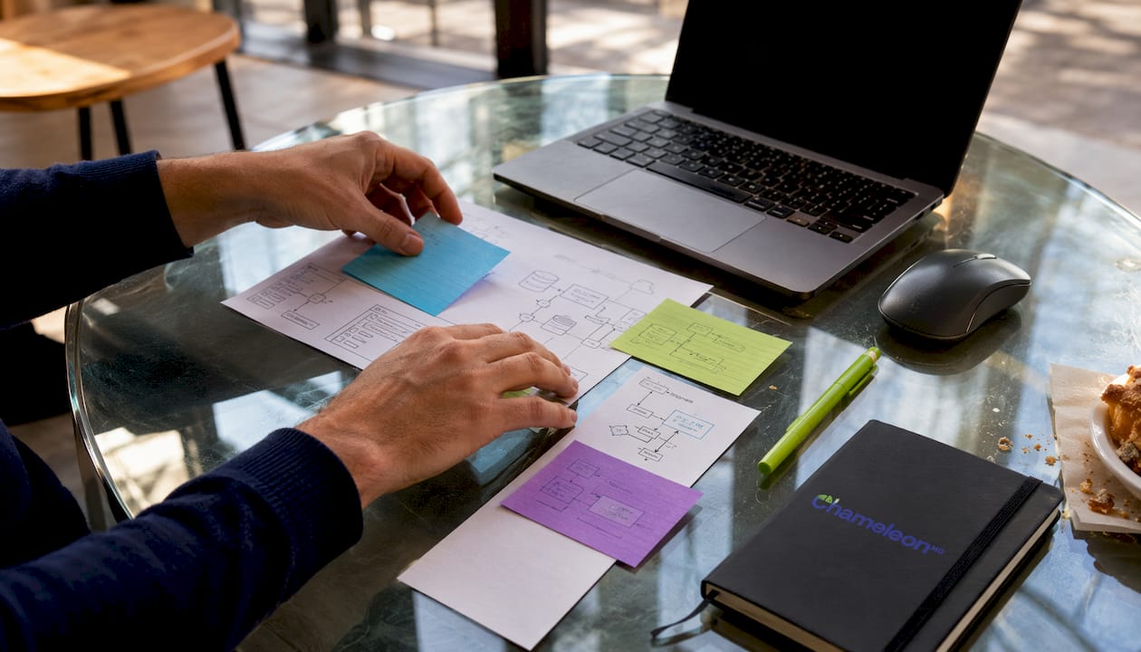 Hands arranging healthcare IT schematics and devices