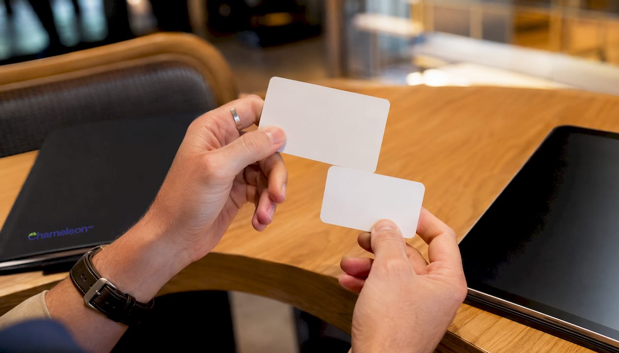 Hands comparing two insurance cards