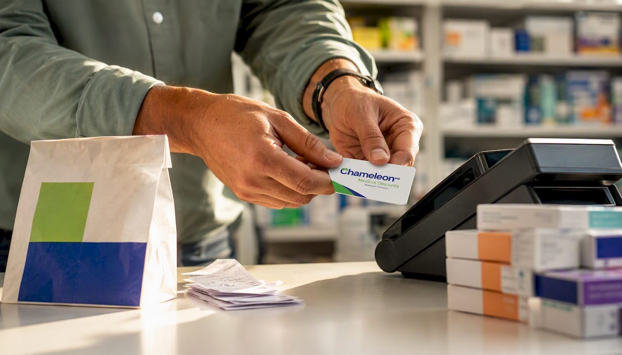 Hands presenting medical discount card at pharmacy counter