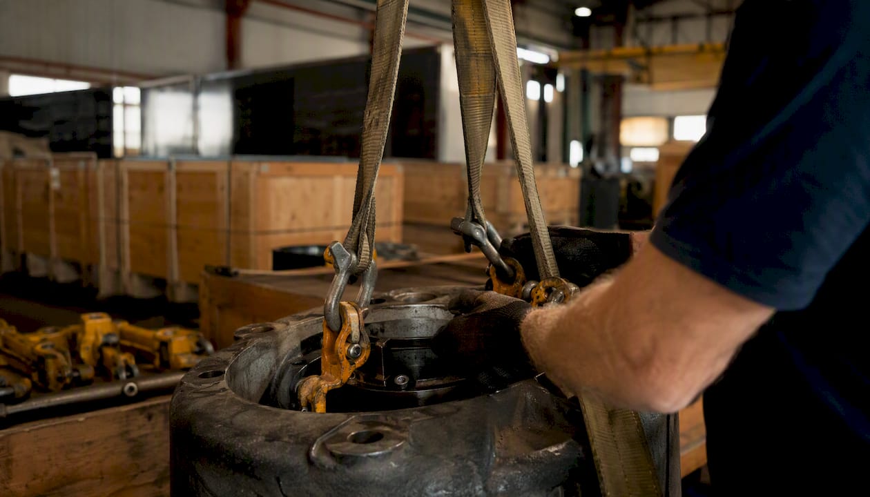 Hands rigging industrial equipment for transport