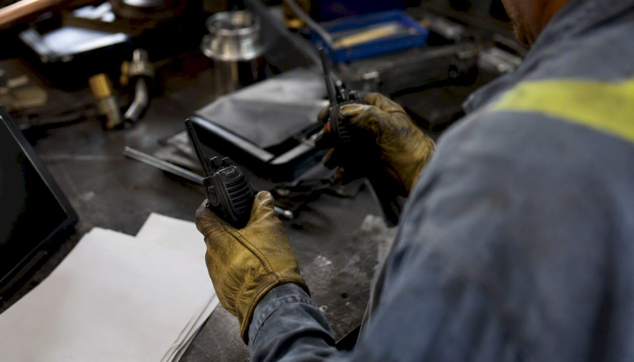 Hands managing contractor radios and paperwork