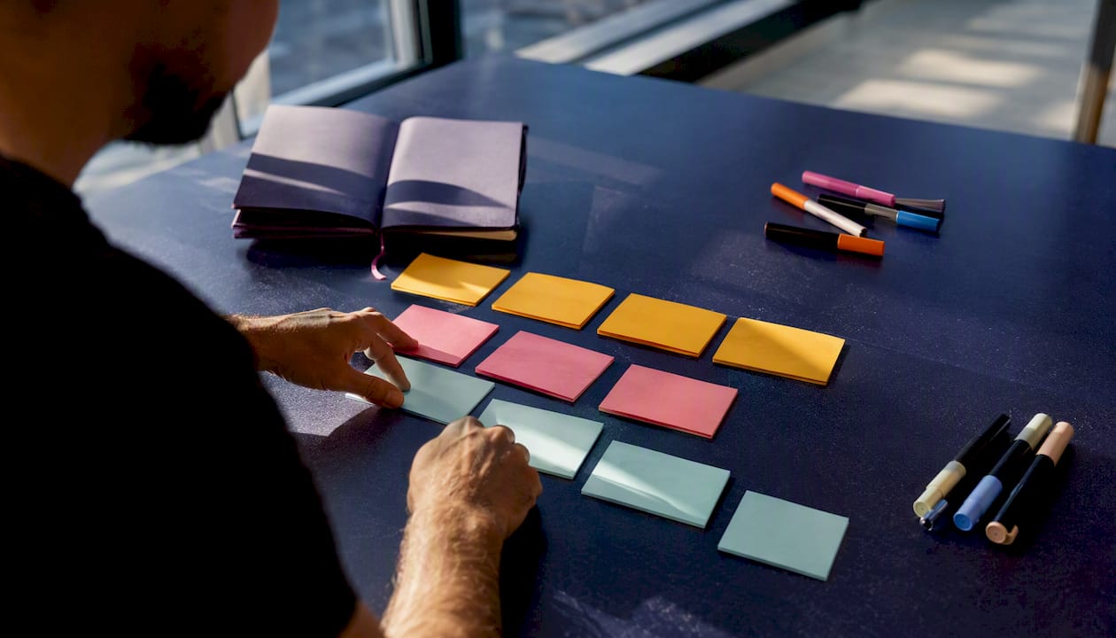 Hands sorting creative slot cards on desk