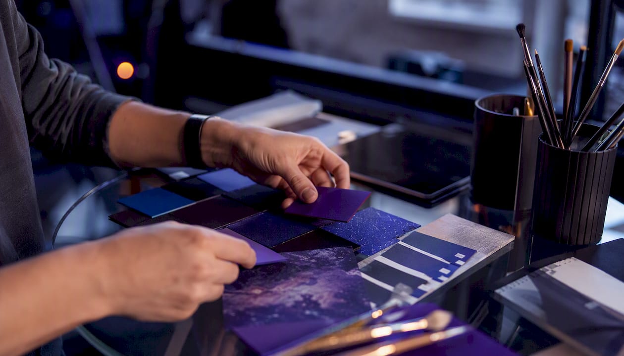 Hands adjusting logo color swatches in design studio