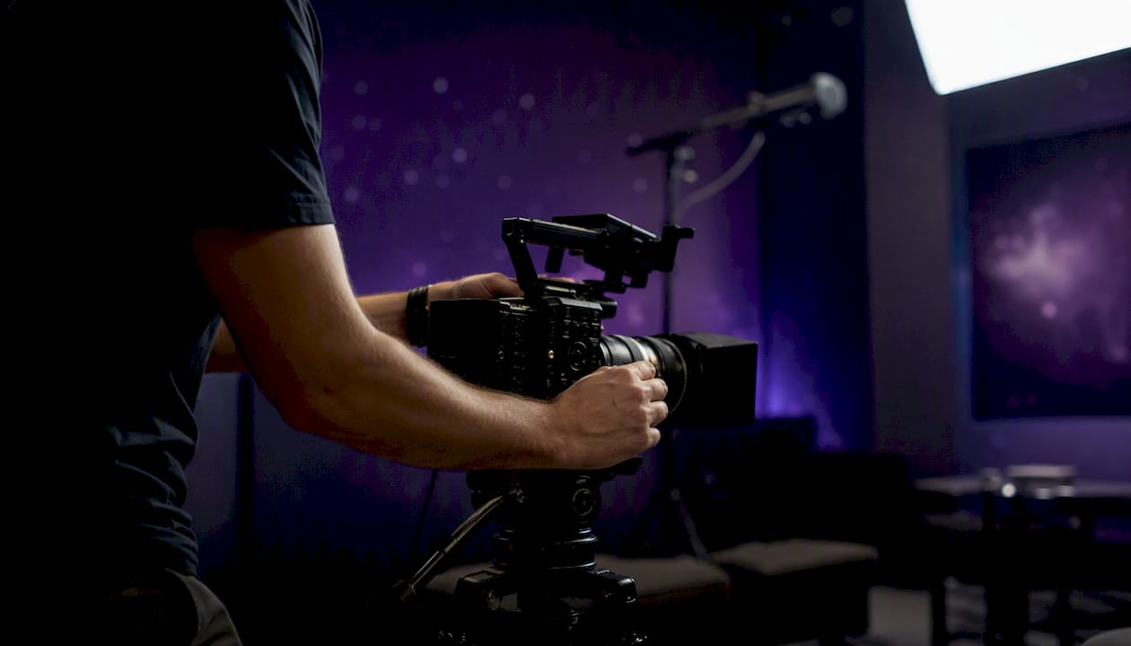 Videographer adjusting camera for interview shoot