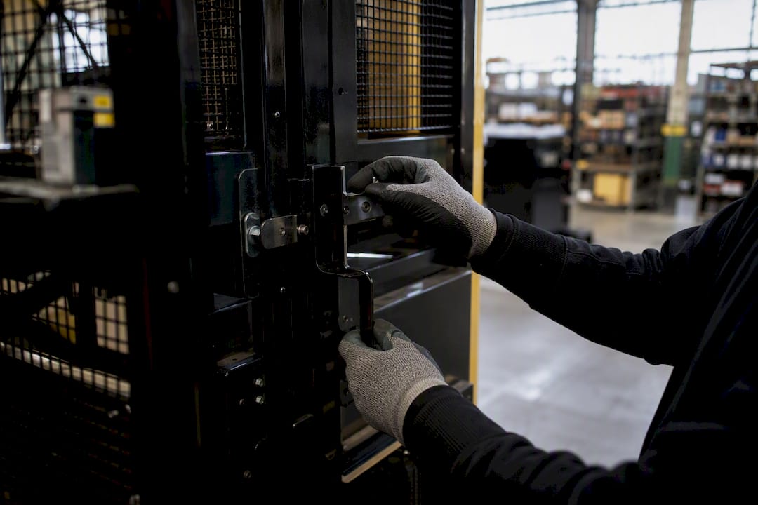 Hands tightening safety guard on machine