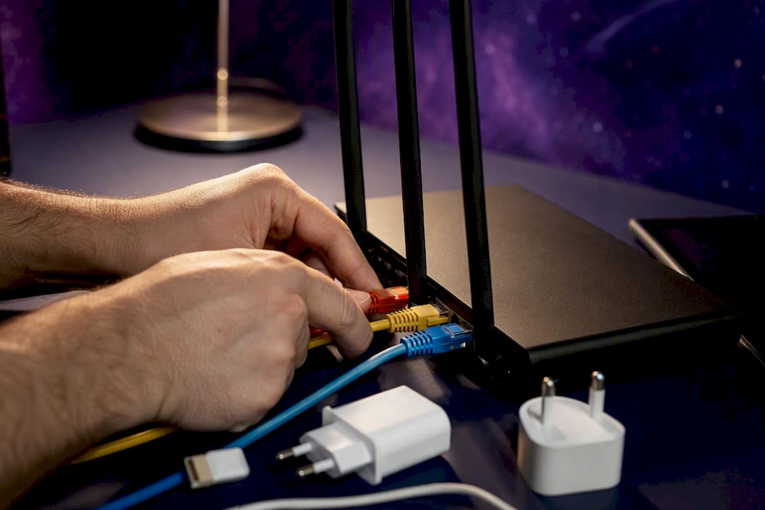Hands connecting cables to router device