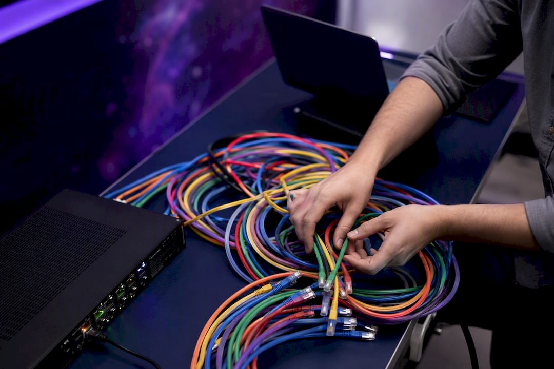 Hands connecting network cables on server rack
