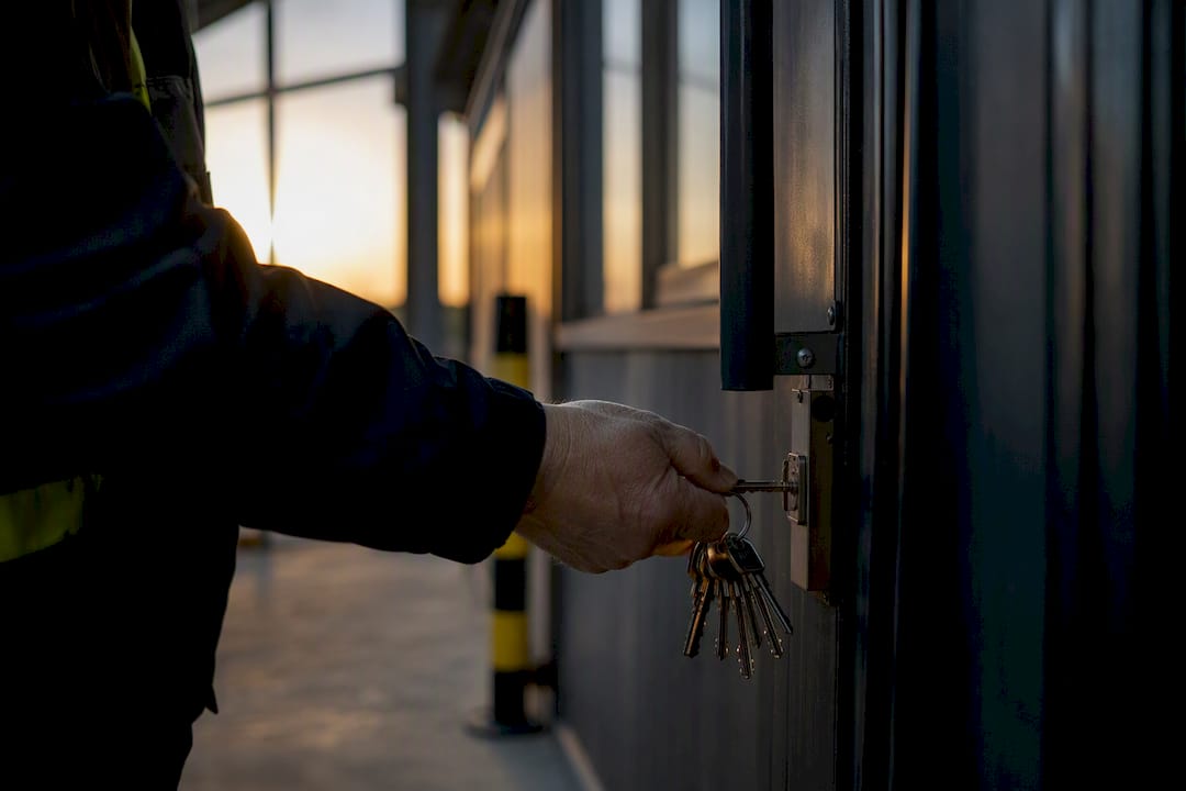 Hand holding industrial keys near door