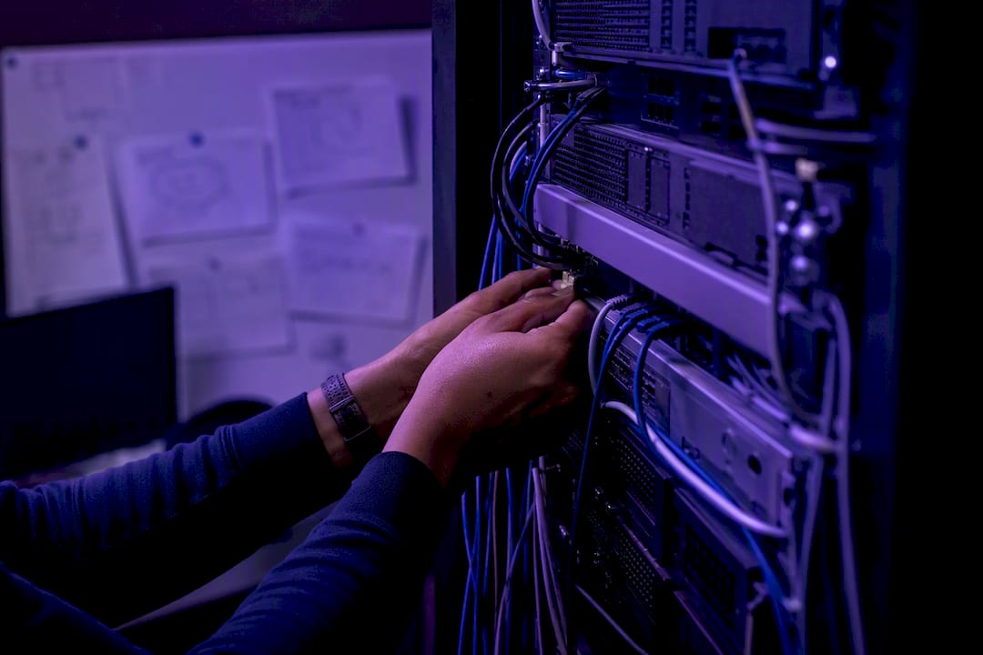 Hands wiring data cables in server rack