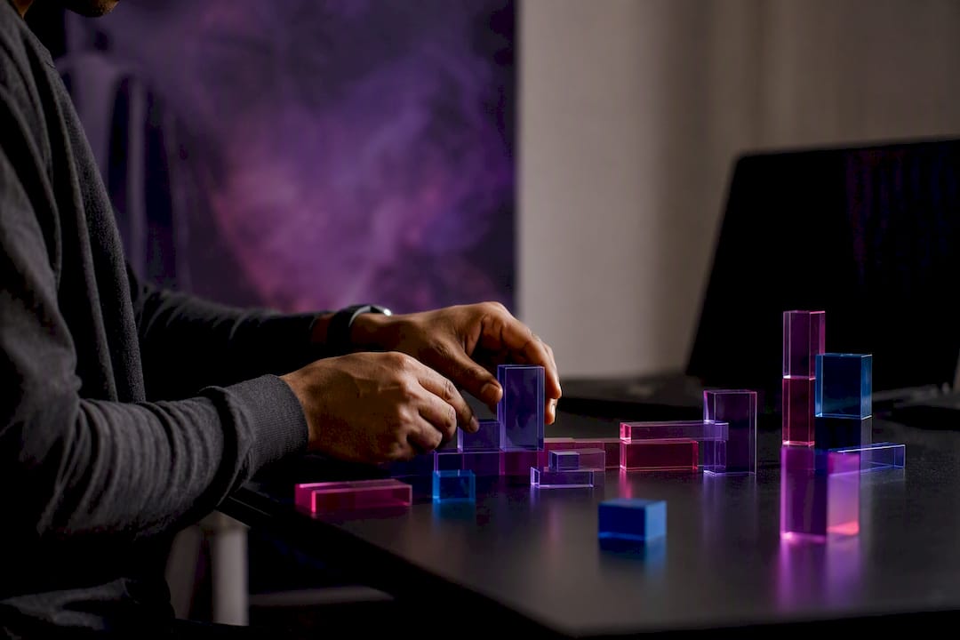 Hands arranging data blocks on purple surface