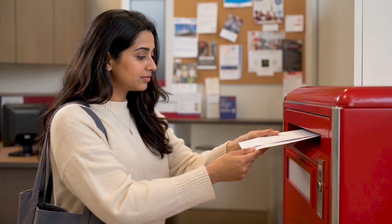 Hands mailing apostille documents at post office