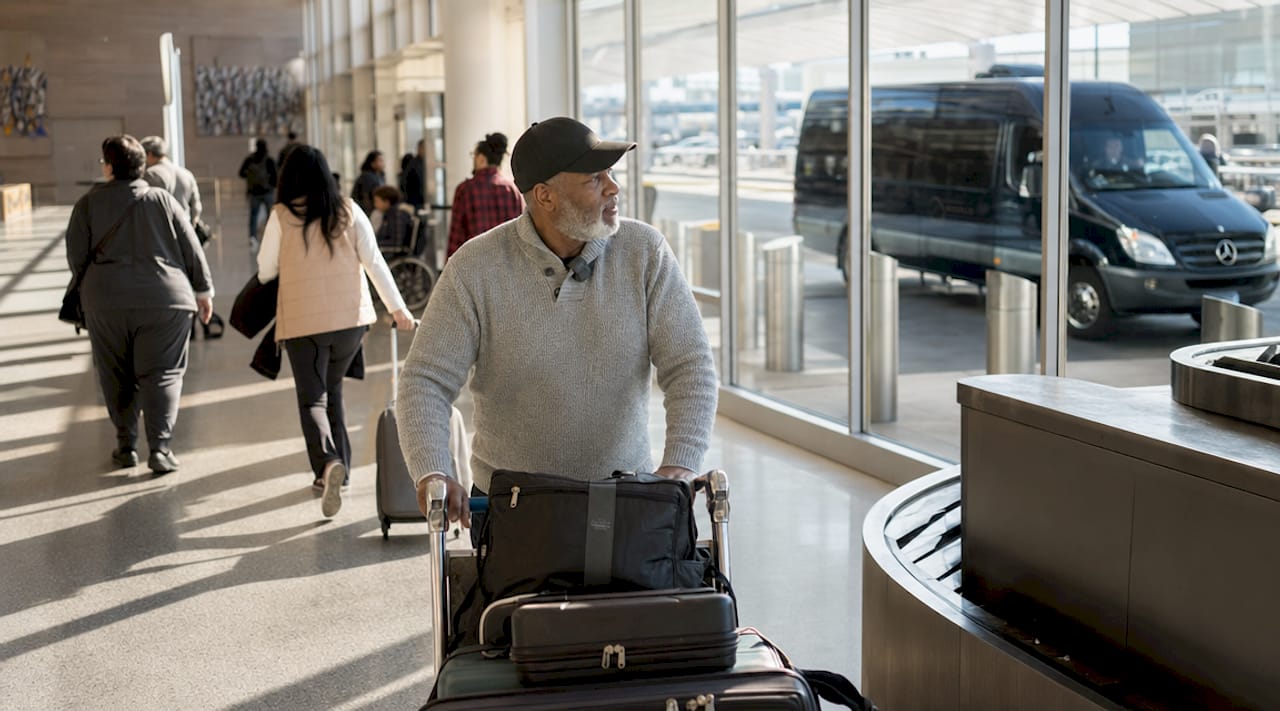 Man pushing luggage cart in international terminal