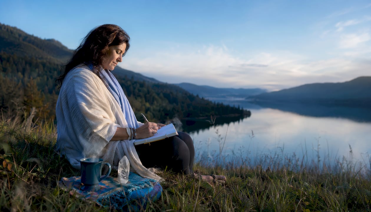 Woman journaling during spiritual travel outdoors