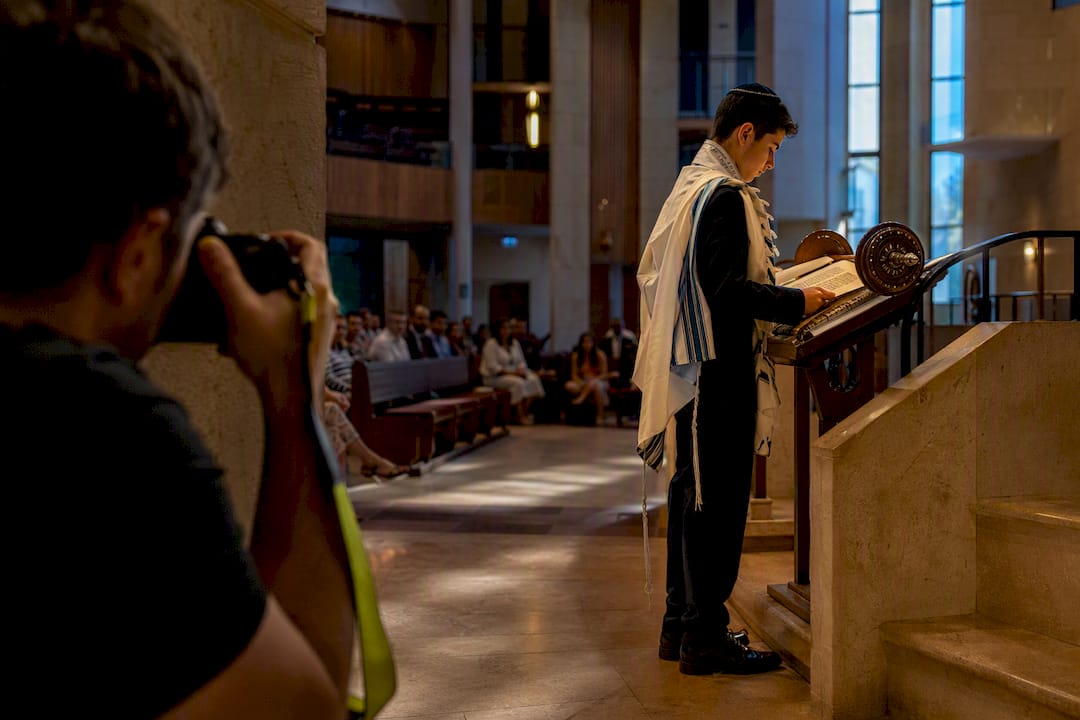 Photographer documenting Torah reading in synagogue