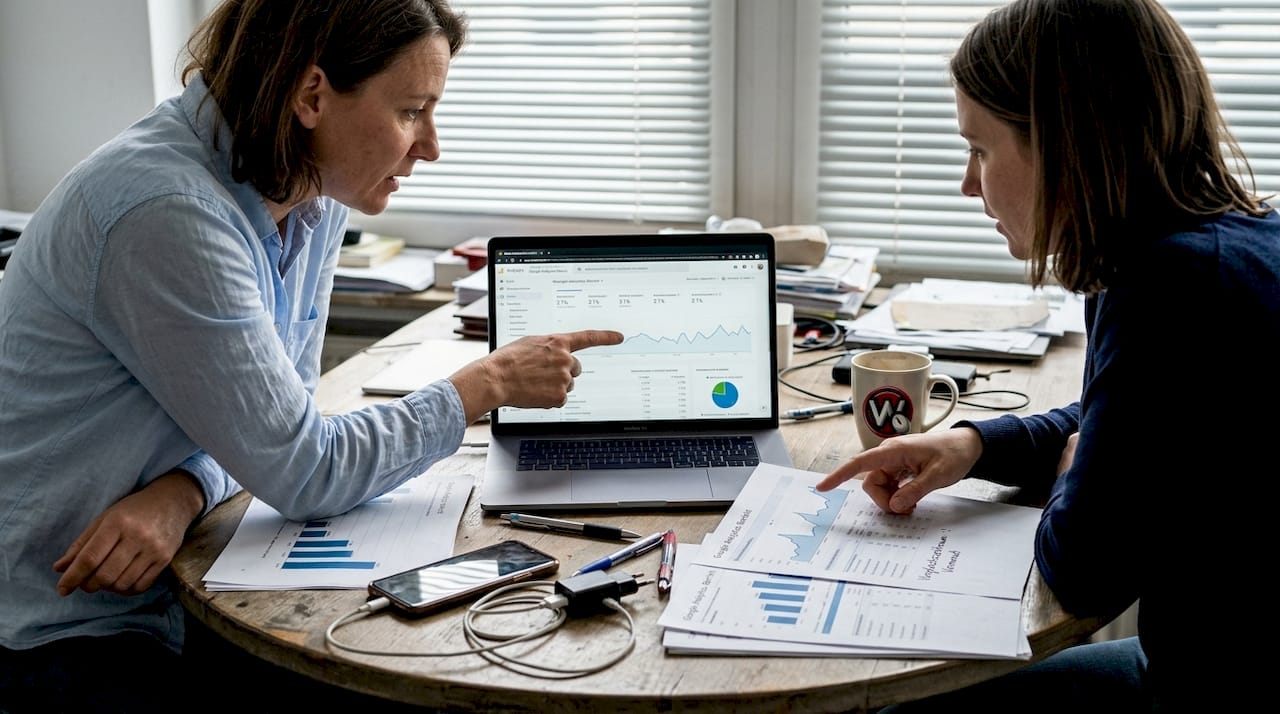 Zwei Kollegen werfen gemeinsam einen Blick auf die Analyse der Conversion-Daten.