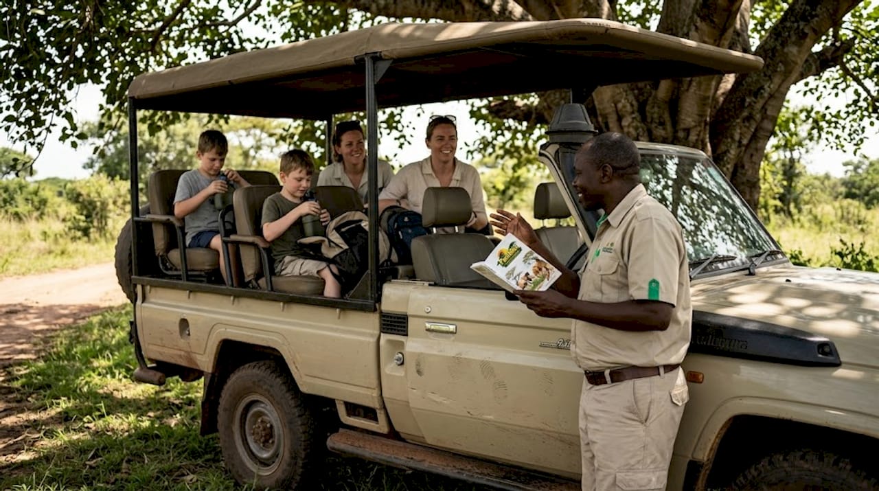 Safari guide explains wildlife to family in 4x4