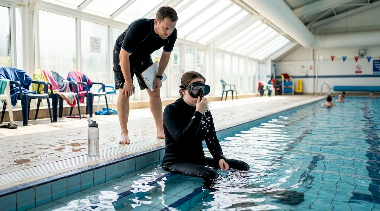 Student practices mask clearing poolside