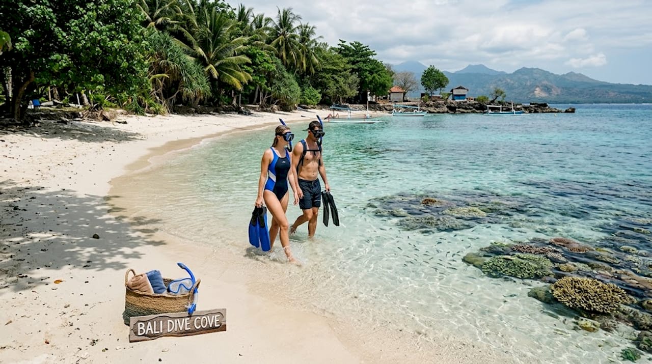 Snorkelers entering Bali fringing reef from shore