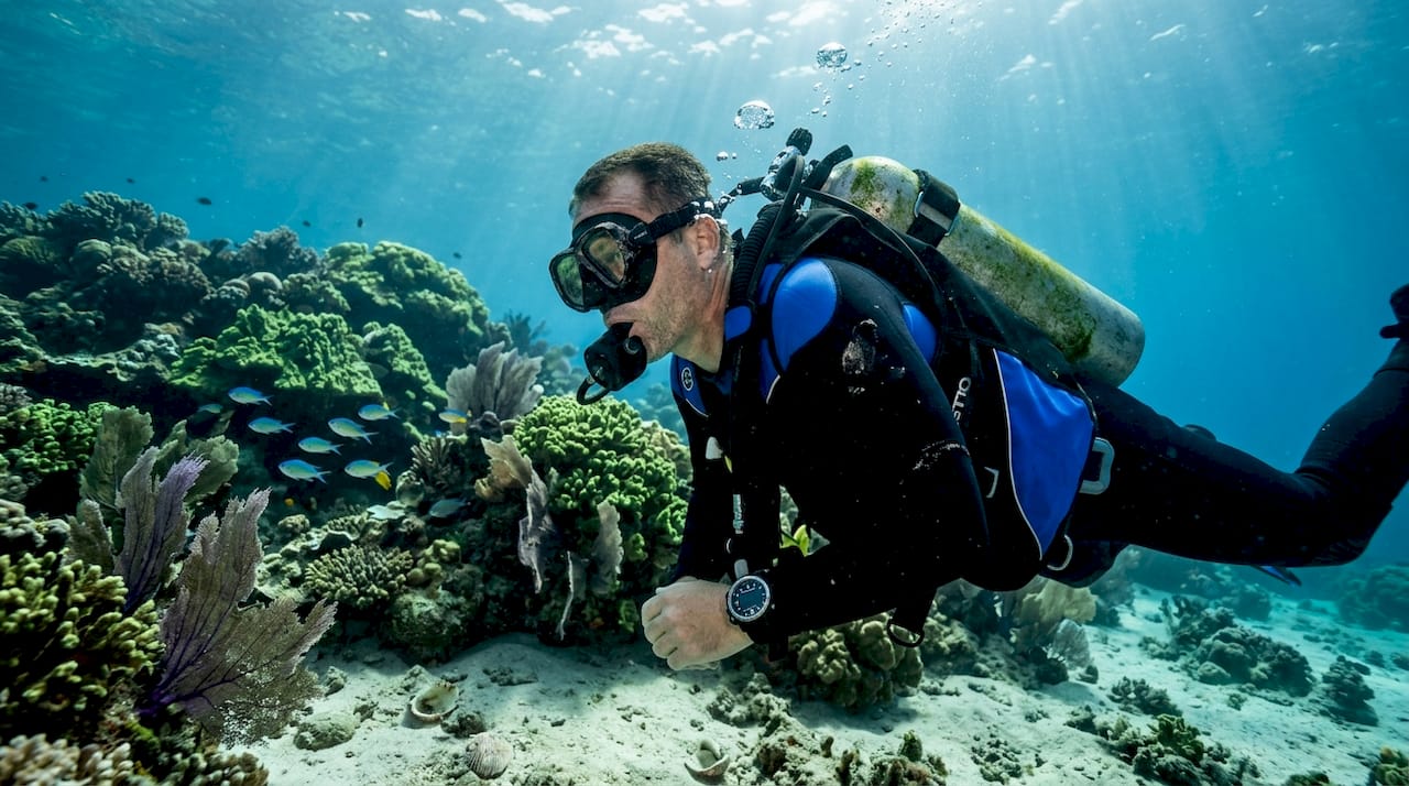 Diver calmly breathing under coral reef