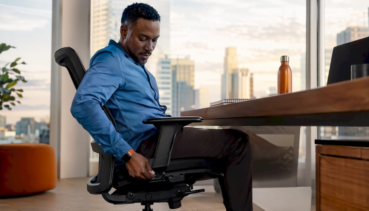 Hands testing ergonomic chair tilt mechanism