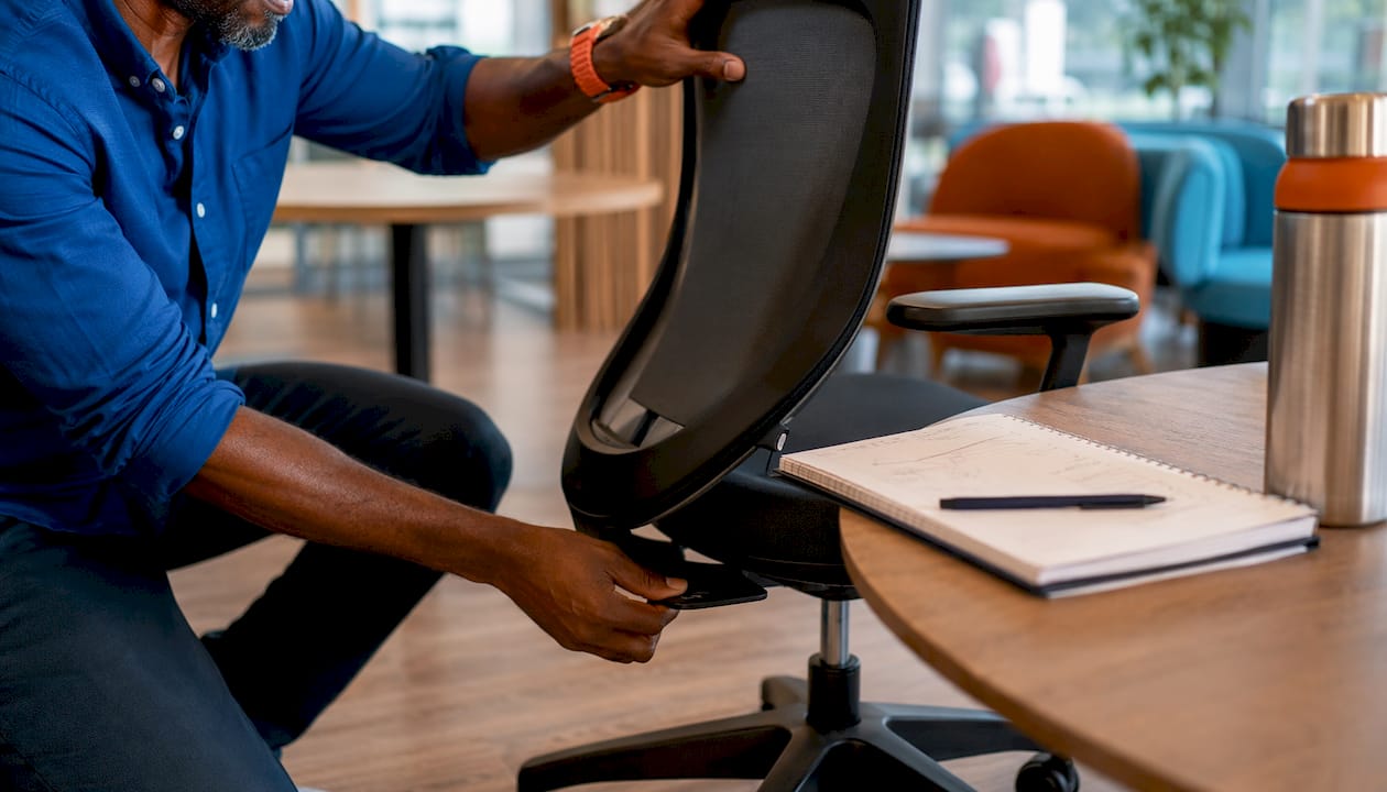 Worker adjusting ergonomic office chair height