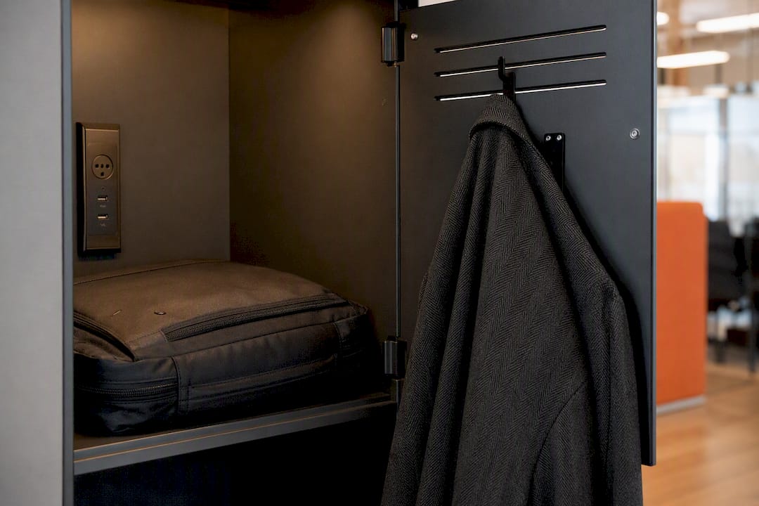 Open locker compartment holding bag and coat