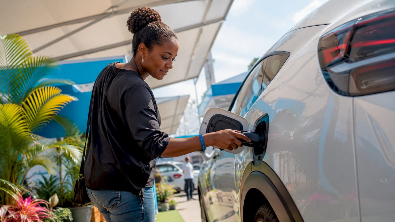 Gratë duke inspektuar portin e karikimit të automjeteve elektrike në showroom