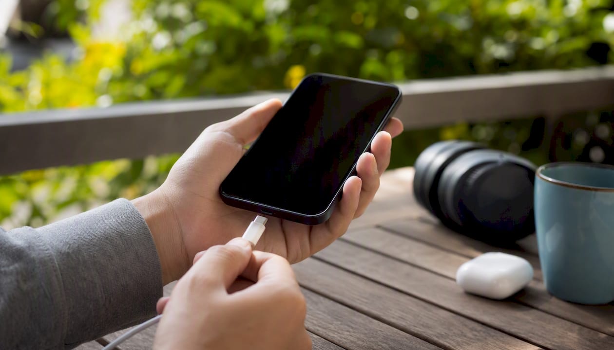 Mano che collega il caricabatterie allo smartphone