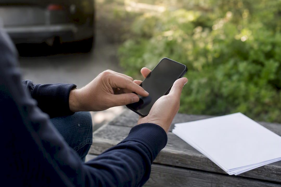 Mani che inseriscono il numero VIN su uno smartphone