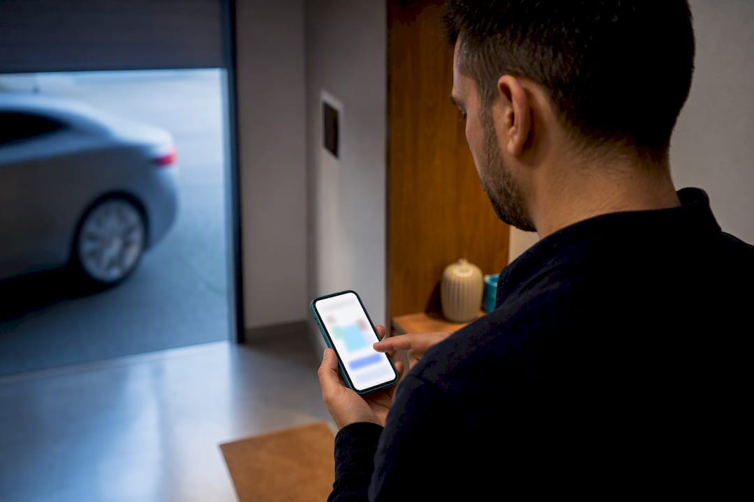 Venditore che aggiorna l'elenco dei veicoli su uno smartphone