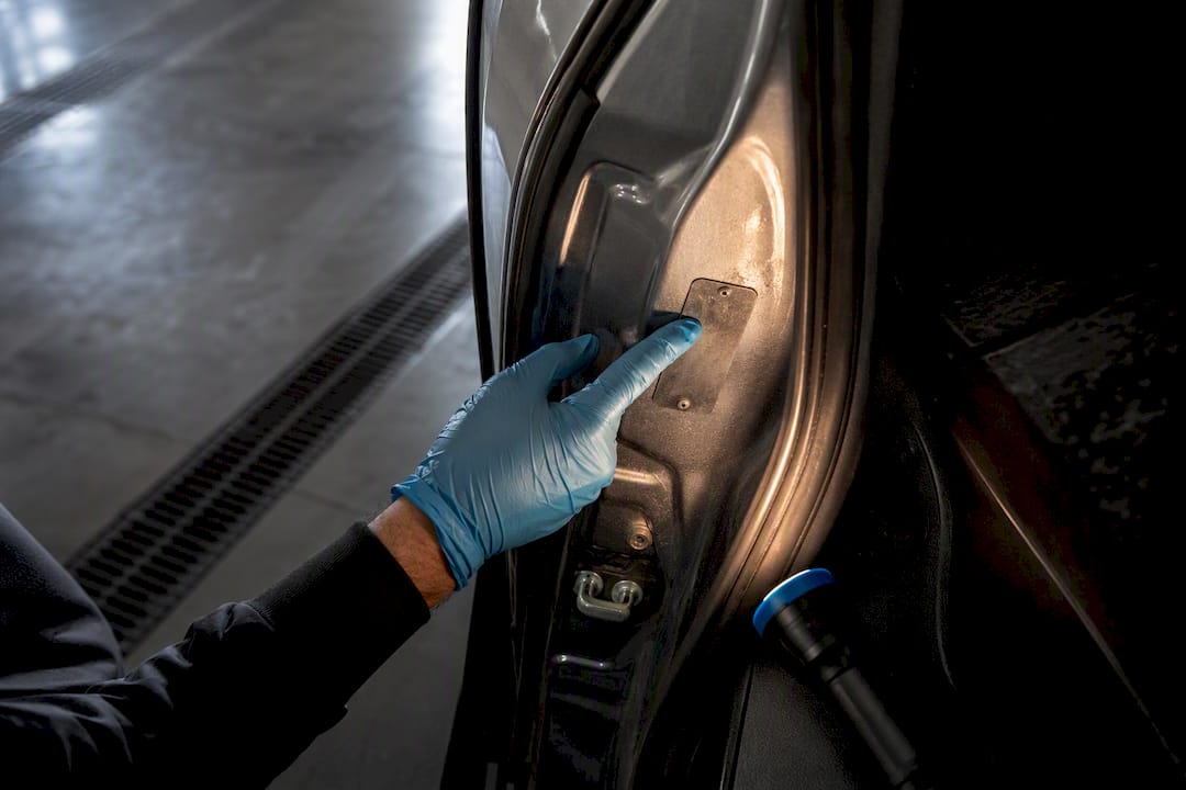 Hand checking an unreadable vehicle VIN plate