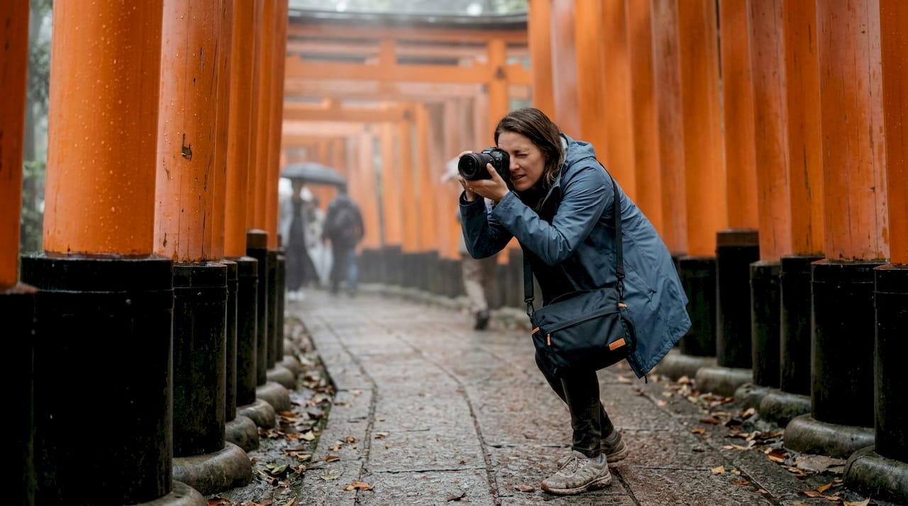 Photographer shooting inside Fushimi Inari torii tunnel