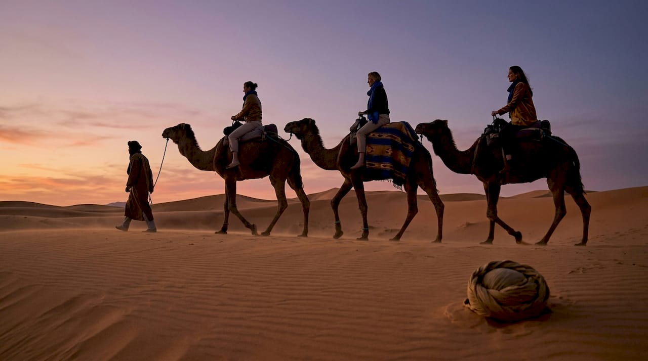 Best Morocco Destinations: Top Places to Visit 1 Camel caravan traversing Sahara dunes sunset