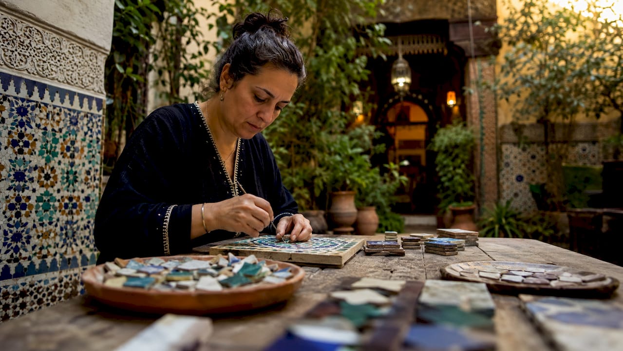 Artisan cutting zellige tiles indoors