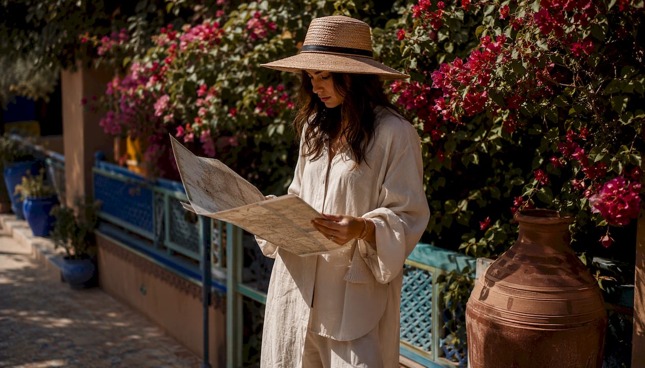 Morocco Packing List: What to Pack for Every Region 2 Woman adjusting hat near medina wall