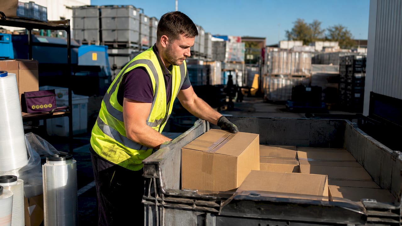 Warehouse worker loading boxes in container