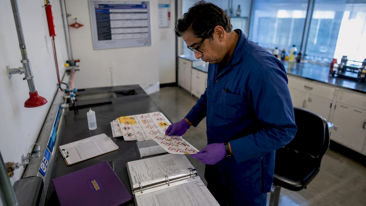 Safety officer reviewing warning labels at desk