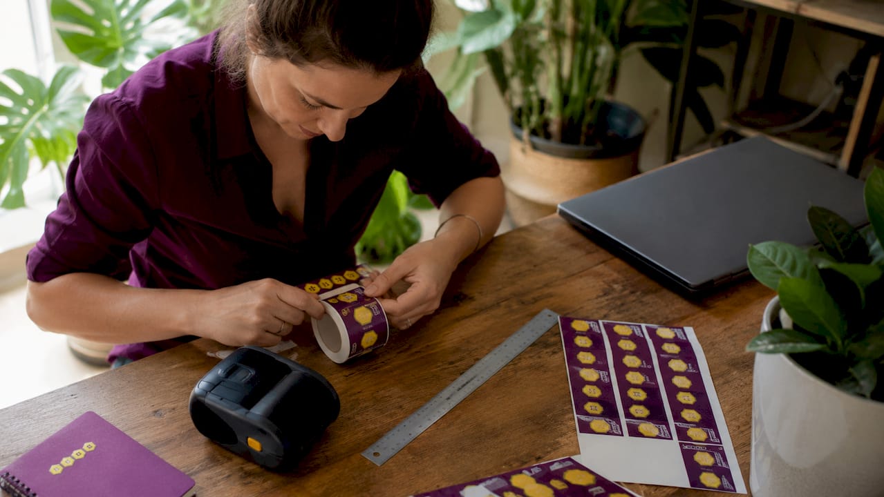 Packaging specialist at workstation handling printed labels