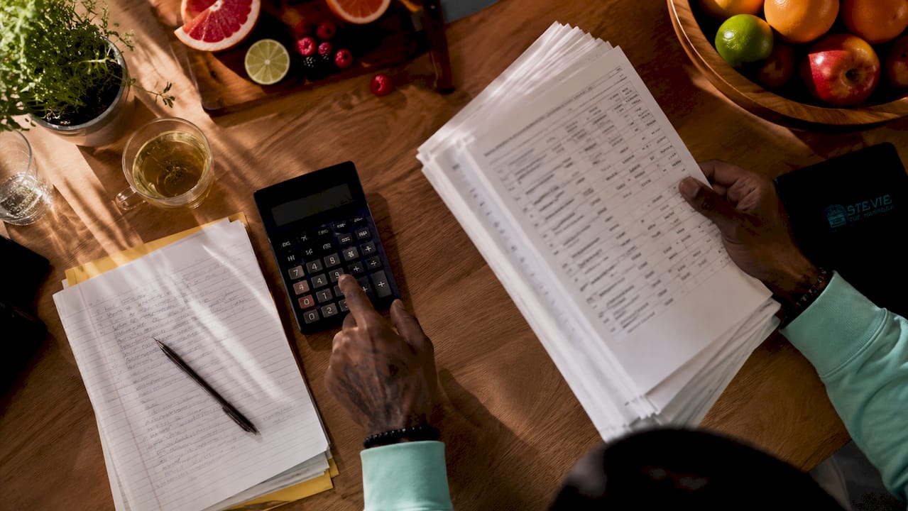 Hands calculating music royalties in office