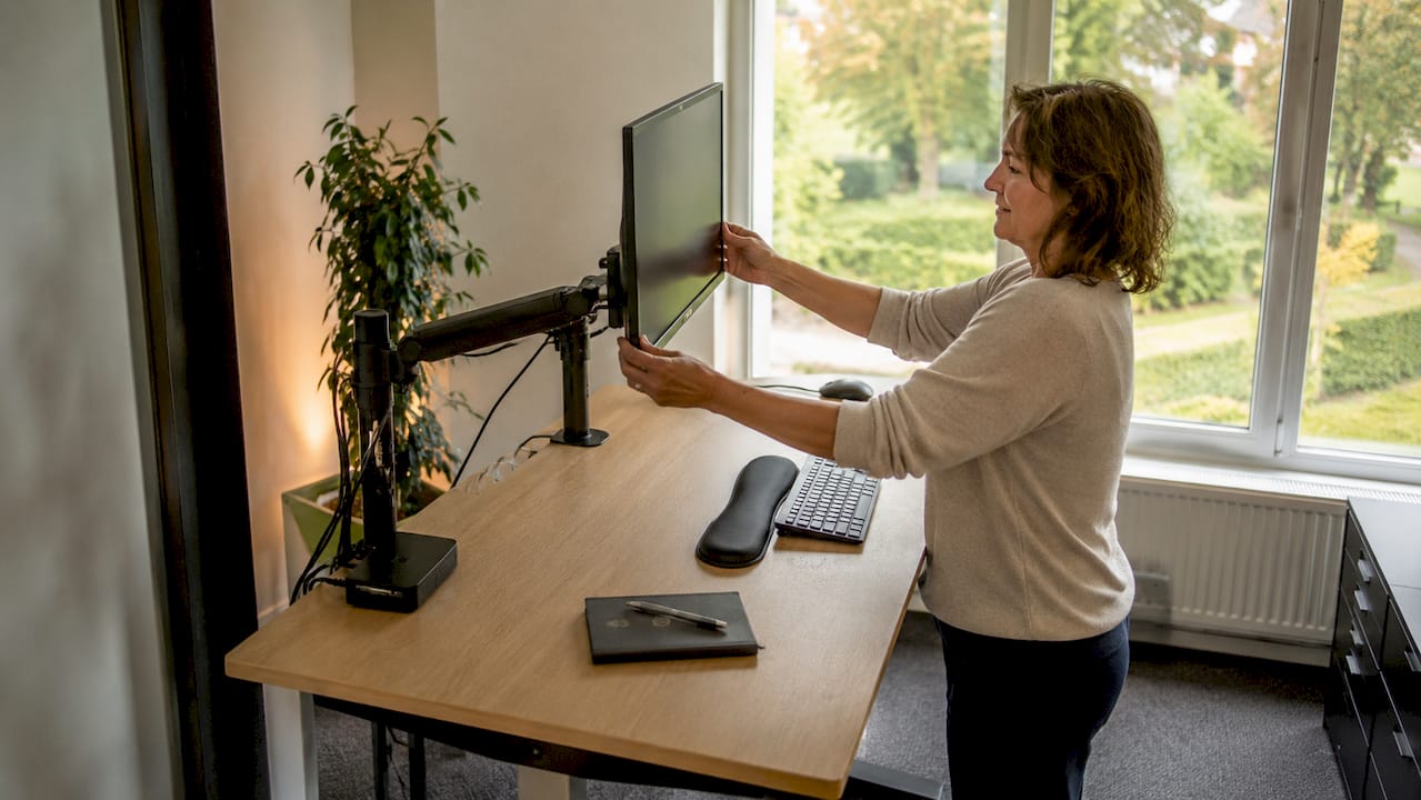 Vrouw creëert een ergonomische werkplek op kantoor