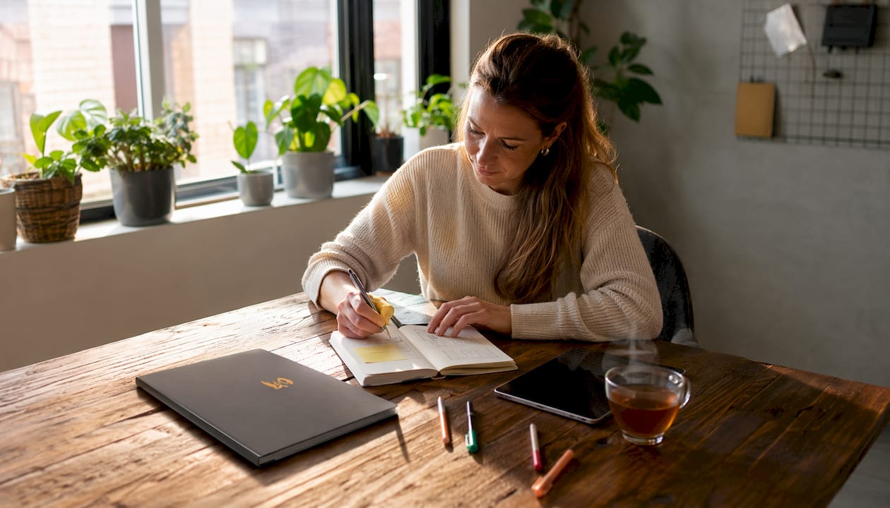 Vrouw achter haar laptop bezig met het organiseren van haar taken